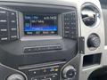 The dashboard of a 2014 Ford F-150 displaying the radio interface with frequency and preset options