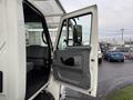 A 2007 International 4200 truck with its driver's side door open, revealing the interior seating and dashboard area