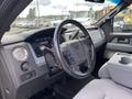 Interior view of a 2013 Ford F-150 showing the steering wheel dashboard and center console