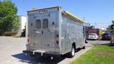 A silver 2005 Morgan Olson Workhorse vehicle with a flatbed and multiple compartments along the sides and back