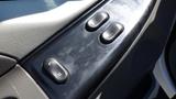 A close-up view of the controls on the driver side door of a 2006 Ford F-650 featuring two buttons marked L and U