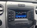 Interior dashboard of a 2014 Ford F-150 featuring a radio display with FM station tuning and various control buttons