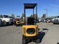 A yellow 2024 AGT H12R machinery with a boxy design and large black grill at the front positioned in a parking lot with other vehicles in the background