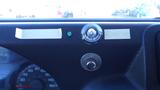 A 2015 Ford Econoline dashboard featuring gauges a button and a small circular light next to adhesive strips