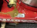 A red 2024 Magnum 4000 Hot Water Pressure Washer with a backflow preventer installation label and visible liquid spill on the surface