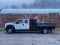 A 2015 Ford F-550 truck with a flatbed and a black storage box mounted on the bed