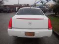 A white 2008 Cadillac Limousine viewed from the rear with distinctive tail lights and a Cadillac emblem on the trunk