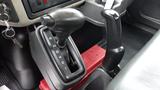 The gear shift of a 2010 International 4300 showing the gear selection positions R N D 4 2 1 on a black console with a red container below