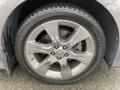 A close-up of a wheel on a 2013 Toyota Sienna showcasing a silver alloy rim and a black tire with visible tread pattern