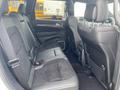 Interior view of a 2018 Jeep Grand Cherokee showing black leather and suede seats in the back row with a spacious design