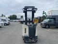 A 2004 Crown RR5210-35 forklift with a grey and white design positioned in a parking area with other vehicles visible in the background