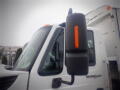 A 2008 International 7400 truck with a prominent side mirror featuring an orange indicator light