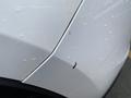 A close-up of a white 2016 Mazda CX-5 with a visible scratch and water droplets on the surface