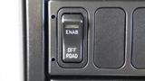 A close-up of a control panel featuring an "ENAB" switch and an "OFF ROAD" switch on a black surface