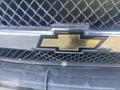 Close-up of a black Chevrolet bowtie emblem on the grille of a 2018 Chevrolet Express van