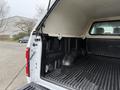 A 2018 Ford F-150 with an empty bed and a white cap on top of the truck bed