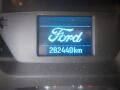 Digital display showing the Ford logo and odometer reading of 282440 kilometers in a 2015 Ford Transit