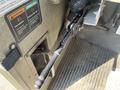 A lever and controls inside a 2010 Freightliner MT45 garbage truck cabin with warning labels and textured flooring