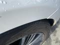 A close-up of a 2020 Land Rover Range Rover Sport highlighting the tire and part of the wheel with water droplets on the vehicle's surface