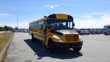 A 2014 International 3000 yellow school bus parked on a lot with its doors closed and headlights on