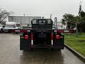 A 2011 International DuraStar 4300 flatbed truck viewed from the rear with red and white reflective tape and taillights visible