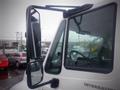 A white 2006 International 4300 truck with a prominent side mirror and window showing raindrops on the glass