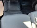 A close-up of the floor space in a 2019 Ford F-350 SD showing a textured black floor mat with the Ford logo and a gray seat covering