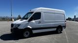 A white 2016 Mercedes-Benz Sprinter van with a sliding side door and black accents parked on a flat surface