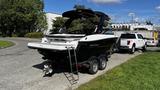 A black and white 2023 Mercury Monterey boat on a trailer with a ladder attached and an outboard motor visible at the back