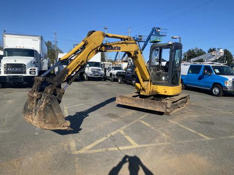 A yellow 2006 Komatsu PC55MR2 excavator with a bucket attachment prominently displayed in the foreground