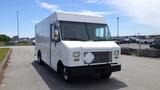 A white 2011 Ford Econoline delivery truck with a large front grille and rectangular headlights parked on a concrete surface