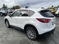 A white 2016 Mazda CX-5 parked with a focus on its rear side and distinctive taillights