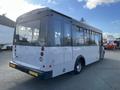 A 2018 Chevrolet Express bus with a white body and large windows viewed from the rear, showcasing its sleek design and rear lights