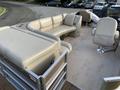 A 2013 Sylvan pontoon boat featuring light-colored seating with a large L-shaped sofa and two captain's chairs positioned at the helm