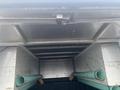 A 2013 Ford F-150 viewed from inside a truck bed with two green pipes resting against the side and a metal framework above