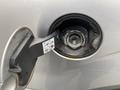 A fuel nozzle inserted into the gas cap of a 2014 Ford F-150 with the label Easy Fuel visible inside the cap