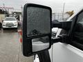 2014 Ford F-550 side mirror with raindrops on the surface showing the reflective glass and housing details