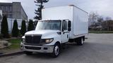 A white 2012 International TerraStar truck with a large box-shaped cargo area and a black grille standing on a paved surface