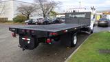 A black 2008 Ford F-650 flatbed truck with a long flatbed and LED lights located at the rear visible from a side angle