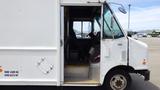 A 2011 Ford Econoline van with a partially open door revealing the driver's seat and dashboard inside