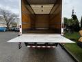 A 2022 Ford F-750 with a lowered loading ramp in the back of its empty cargo area