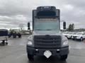 A 2018 Hino 308 truck viewed from the front with a large black cab and grill featuring the Hino emblem and bright orange lights on top