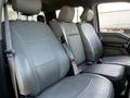 Interior of a 2017 Ford F-150 showing two front seats with grey leather upholstery and seatbelts attached