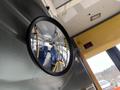 Interior view of a 2018 Chevrolet Express showcasing a round mirror reflecting empty bus seats and yellow accents