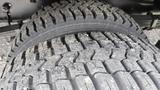 Close-up of a 2006 Ford Econoline tire showcasing a textured tread pattern with visible wear and debris