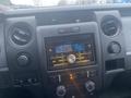 Interior dashboard of a 2013 Ford F-150 featuring a car stereo system with digital display and adjustable knobs for volume and settings