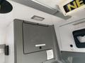 Interior view of a 2018 Chevrolet Express showing a gray panel with a storage compartment and a light fixture above