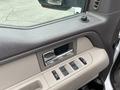 Interior door panel of a 2010 Ford F-150 featuring window controls and a metallic handle