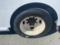 Close-up of a rusty 2007 Freightliner MT55 tire showing worn tread and a white wheel rim with visible rust spots