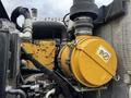 A close-up of a yellow air filter attached to a mechanical assembly with various pipes and connectors in a 2007 Tennant Sentinel